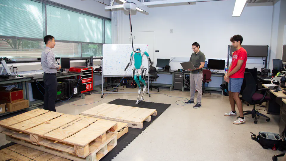 Digit on a walking mat in the Cyberbotics Lab, with researchers and stepping platforms nearby.